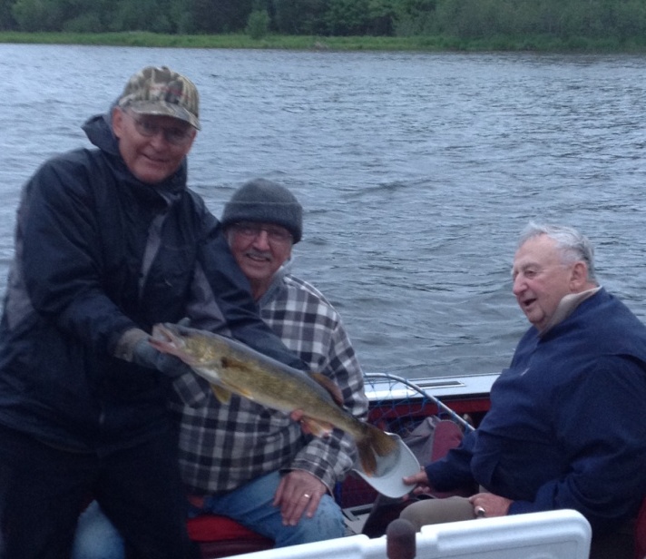 Dave holds a 25 inch walleye that cousin George N caught and released on Benoit Lake.  Uncle John admires the fish.
