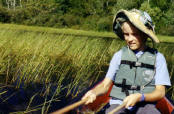 Jacob uses traditional cedar "knockers" to gather wild rice from a local lake.